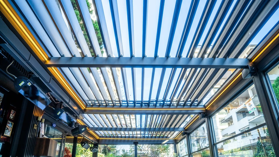 Pergola bioclimatique avec lames orientables en aluminium blanc installée sur terrasse extérieure