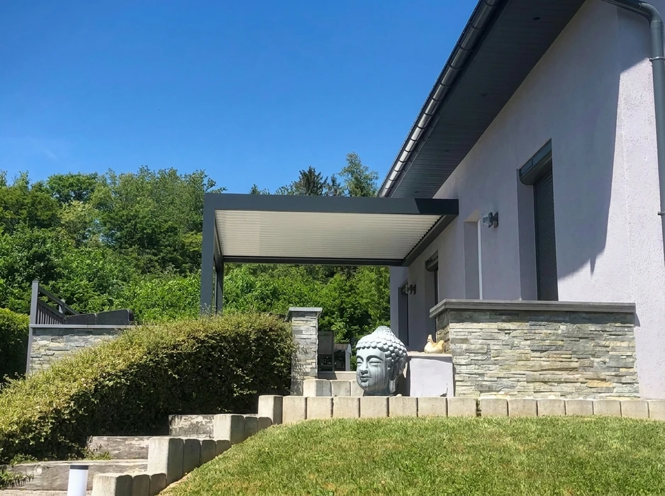 Maison individuelle de style alsacien, façade crépi beige, toiture en tuiles terre cuite équipée de **capteurs solaires thermiques** (3 panneaux plats)