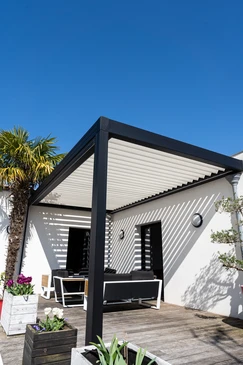 Terrasse extérieure résidentielle moderne avec pergola métallique à structure aluminium gris anthracite et couverture polycarbonate translucide