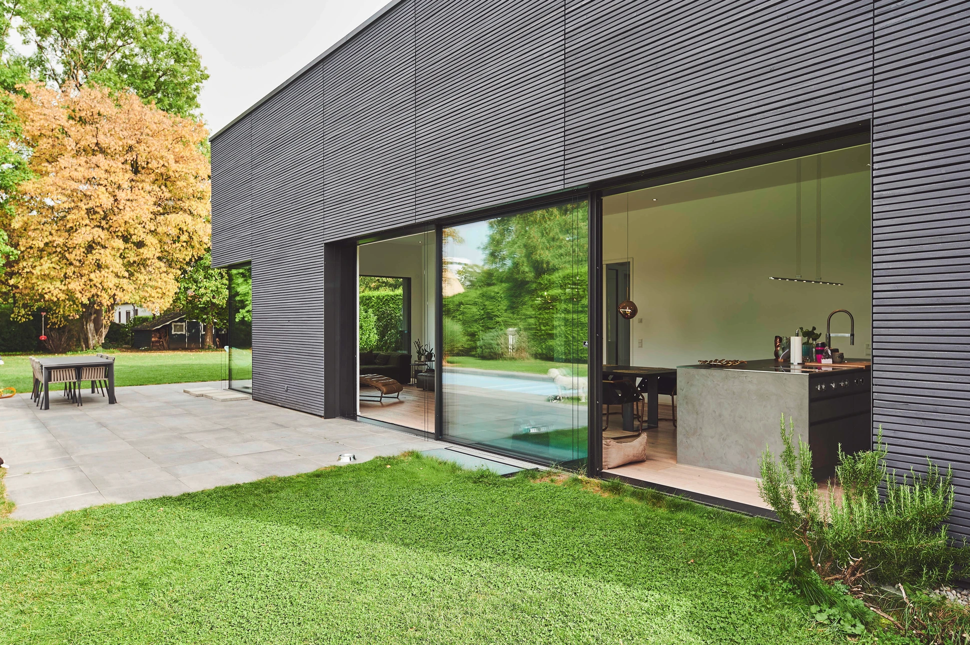Intérieur résidentiel avec fenêtre ouverte donnant sur jardin boisé