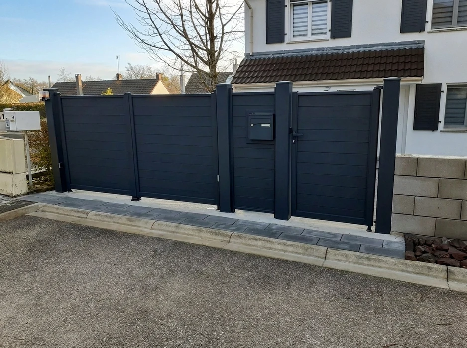 Pergola bioclimatique à lames orientables en aluminium anthracite, fixée en applique sur façade de maison individuelle en bardage clin beige