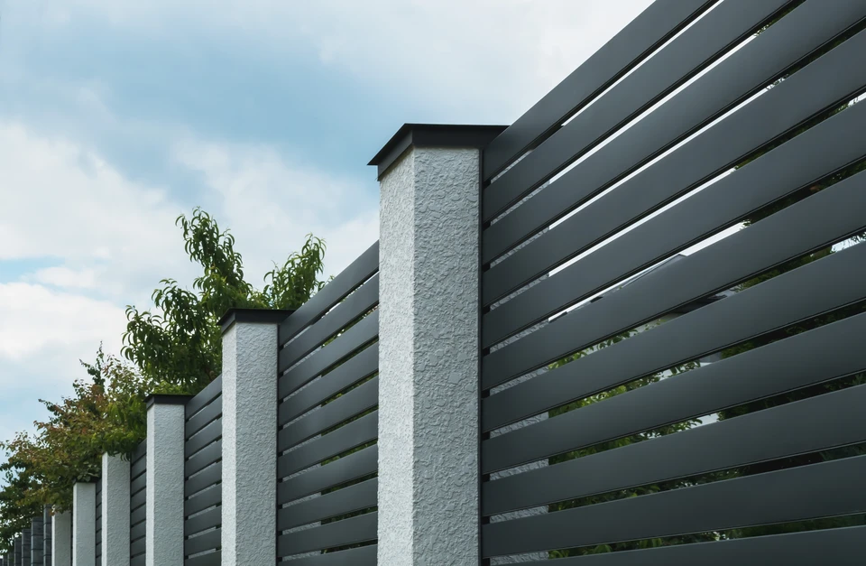 Entrée résidentielle moderne avec portail coulissant et portillon en aluminium anthracite, piliers en béton blanc