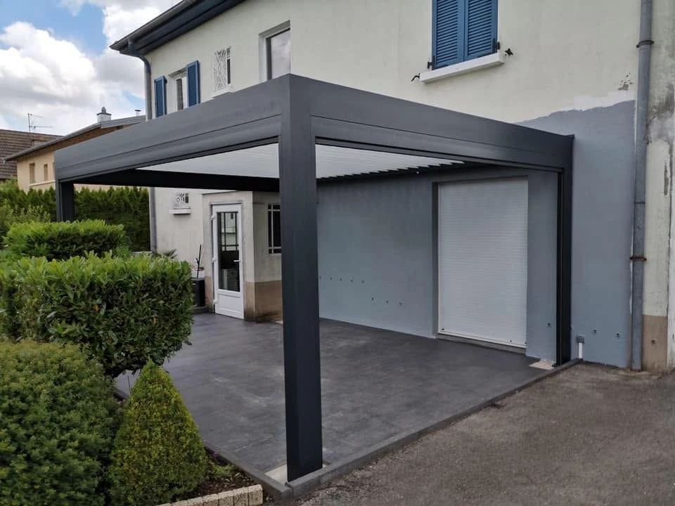 Jardin résidentiel avec clôture à lames horizontales en aluminium anthracite, pergola en bois naturel avec plantes grimpantes, massifs de végétaux sur substrat de paillis